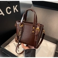 Dettaglio ravvicinato della borsa vintage in pelle marrone scuro nella confezione regalo - Caffè con Ciondolo