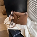 Brown frosted leather saddle bag with gold buckle and woven charm on tweed fabric - Brown with Pendant