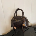 Deep brown vintage leather pillow bag with gold hardware and stylish charm detail - Coffee with Pendant