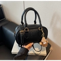 Detail of black Boston bag with textured leather, gold hardware and plush bear charm - With Charm / Black