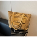 Detalle del bolso tote de lona caqui con bolsillo frontal y botón de presión metálico - Caqui