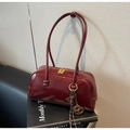 Détail du sac bowling en cuir verni bordeaux avec zip doré et longue bandoulière - Avec Pendentif / Bordeaux