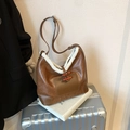 Braune Beuteltasche mit Pelzbesatz und Holzknöpfen auf einem Koffer dekoriert - Braun