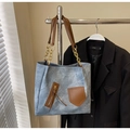Close-up of a blue denim tote bag featuring brown leather straps and gold chain accents - Denim Blue Without Pendant