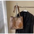 Detailed close-up of brown textured leather tote bag with stylish gold chain strap detail - Coffee No Charm