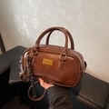Vintage dunkelbraune Boston Tasche mit goldener Plakette und Knotenanhänger - Braun mit Anhänger