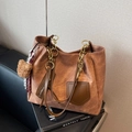Grande borsa tote marrone scuro con catena dorata e ciondolo a orsetto su divano - Marrone con ciondolo