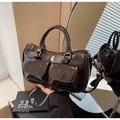 Detail der dunkelbraunen Glanzleder-Handtasche mit Vordertaschen und Vintage-Metallteilen - Kaffeebraun