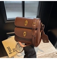 Detail of vintage brown leather crossbody bag with dual golden twist-lock closures - Brown