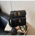Close-up of black crossbody bag featuring dual front pockets and gold turn-lock buckles - Black