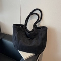 Minimalist black plush tote bag in heavy textured wool fabric on leather chair - Black