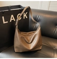Détail de la bandoulière réglable avec boucle dorée sur un sac cabas marron foncé - Gris