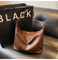 Détail du sac hobo en cuir marron vintage montrant la texture cirée et le zip - café