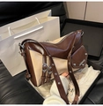 Detalle de bolso bajo el brazo de patchwork marrón y beige con hebilla de metal en caja - Café & Beige