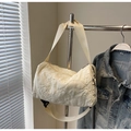 Dettaglio della borsa cilindrica trapuntata crema con trama 3D e tracolla in nylon largo - Bianco Sporco