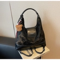 Dettaglio della borsa hobo nera con trama vintage e ciondolo a forma di orsetto bruno - Nero (Con Ciondolo)