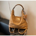 Dettaglio della borsa tote marrone con ciondolo a orsetto e sciarpa a scacchi su divano - Cachi (Con Ciondolo)