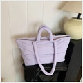 Lavender quilted down tote bag with double handles shown in a cozy studio setting - Purple