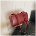 Detail of a retro burgundy pillow bag featuring twin straps and a detachable coin pouch - Red