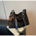 Dettaglio borsa hobo in pelle scamosciata nera con tracolla e ciondolo con frange - Nero con ciondolo