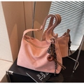 Dettaglio della borsa tote in pelle scamosciata rosa con ciondolo decorativo in legno - Rosa con ciondolo