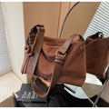 Dettaglio borsa tote in pelle scamosciata marrone con ciondolo e tracolla larga - Caffè con Ciondolo