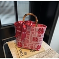 Detalle del bolso de boda rojo con asa de bambú, estampado jacquard y elegante lazo de seda - Rojo (Da Xi)