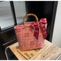 Detalle de bolso de boda rojo con asas de bambú y lazo decorativo Doble Felicidad - Rosa (Da Xi)