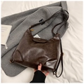 Detail of vintage dark brown faux leather hobo bag with pleated bottom and bronze hardware - Brown