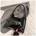 Dettaglio borsa hobo nera minimalista con anello dorato su cappotto elegante - Nero