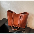Primer plano del bolso tote de cuero caramelo con textura vintage y costuras blancas - Marrón