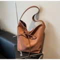Detail of a brown vintage tote bag showing soft suede texture and leather bow tie decoration - Brown