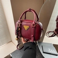 Vintage bordeauxrote quadratische Umhängetasche mit goldener Logo-Plakette und Anhänger - Rot (Mit Anhänger)