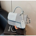 Detailed view of bicolor patchwork crossbody bag with premium leather and fabric texture - Blue