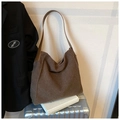 Detalle de textura de bolso tote de lana con asa de cuero sobre una maleta - Café Claro