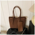 Grand sac cabas en daim marron foncé avec pochette assortie posé sur une surface en cuir - Marron