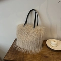 Fuzzy beige faux fur tote bag with black leather straps on a wooden table - Beige