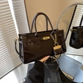 Große dunkelbraune Handtasche aus Glanzleder mit Goldschnalle und Mini-Anhänger - Schwarz (Mit Anhänger)