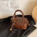 Retro dunkelbraune Boston-Handtasche aus glänzendem Leder mit Prägung und Quaste - Braun mit Anhänger