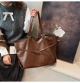 Detail of adjustable leather strap and metal buckle on dark brown retro tote bag - Brown