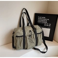 Close-up of khaki nylon tote bag with drawstring pocket and silver metal carabiner - Green