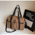 Detail of nylon tote bag with silver carabiner and black woven straps in brown coffee - Khaki