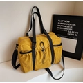 Dettaglio di una borsa tote in nylon giallo senape con tasche laterali elastiche e moschettone - Giallo