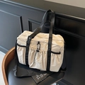 Beigefarbene Nylon-Tragetasche mit schwarzen Riemen und verstellbarem Schultergurt - Cremeweiß