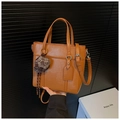 Detail of brown faux leather bucket bag featuring a plaid hat charm and silver hardware - Brown with Pendant