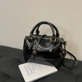 Schwarze Boston-Tasche aus glänzendem Leder mit weißen Kontrastnähten und Gold-Hardware - Schwarz