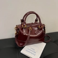 Dark red Boston handbag with glossy finish, gold hardware, and white contrast stitching - Red