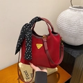 Sac seau rouge rétro avec foulard à pois et bandoulière amovible dans un décor élégant - Rouge