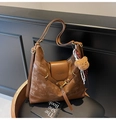 Close-up of retro brown leather tote bag with gold swivel lock and plush bear charm - Brown (With Pendant)