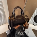 Borsa a cilindro marrone scuro con manici e un simpatico ciondolo a forma di scimmia - caffè